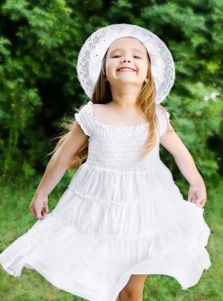 Portret van schattige lachende meisje in witte jurk en hoed — Stockfoto