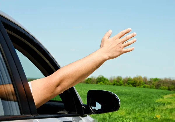 Hombre dentro del coche mostrando su mano — Foto de Stock