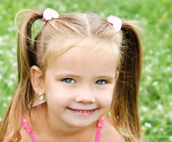 Милая улыбающаяся маленькая девочка на лугу — стоковое фото