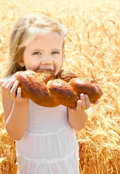 Söt liten flicka äter bröd — Stockfoto