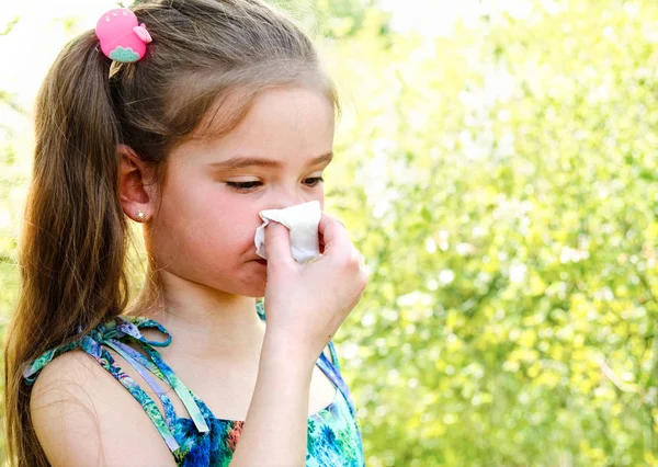 Dziewczynka ma alergię na wiosnę kwitnących i dmuchanie jej nos — Zdjęcie stockowe