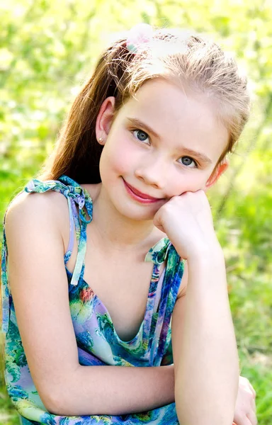 Портрет очаровательной улыбающейся маленькой девочки на открытом воздухе — стоковое фото