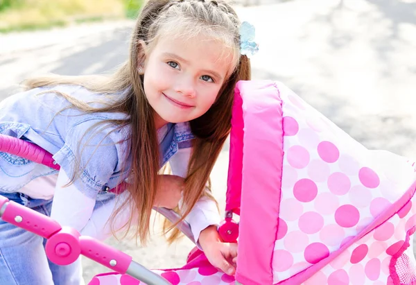 Petite fille souriante mignonne jouant avec son chariot de jouet — Photo