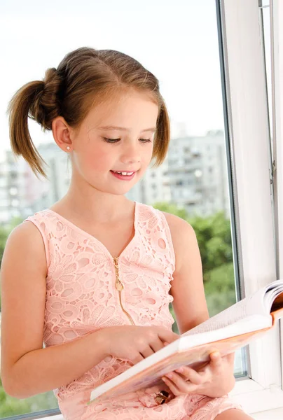 Adorável menina criança está lendo um livro — Fotografia de Stock