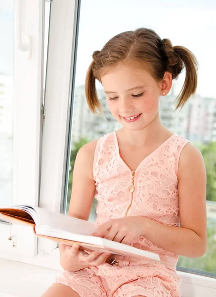 Adorable little girl child is reading a book — Stock Photo, Image