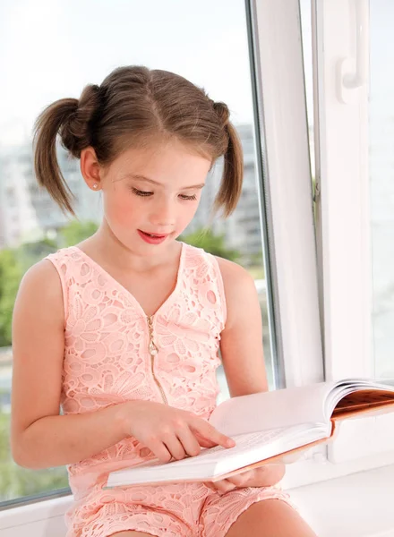 Adorable little girl child is reading a book — Stock Photo, Image