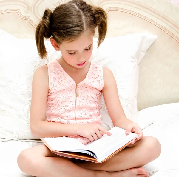 Adorável menina criança está lendo um livro — Fotografia de Stock