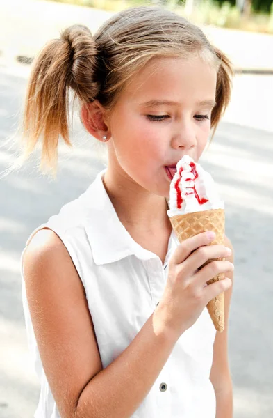 Linda niña sonriente comiendo un helado — Foto de Stock
