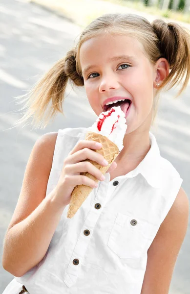 Linda niña sonriente comiendo un helado — Foto de Stock