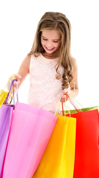 Adorable niña buscando en el pape de compras colorido — Foto de Stock