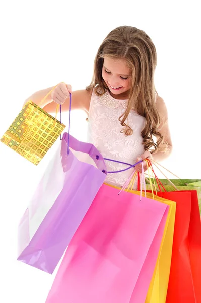 Adorable niña pequeña sosteniendo compras coloridas bolsas de papel — Foto de Stock