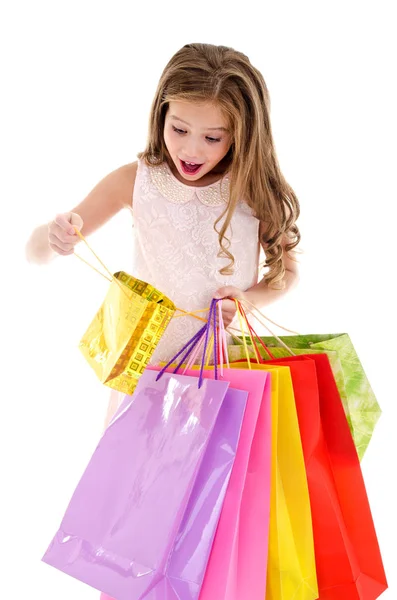 Adorable niña pequeña sosteniendo compras coloridas bolsas de papel —  Fotos de Stock