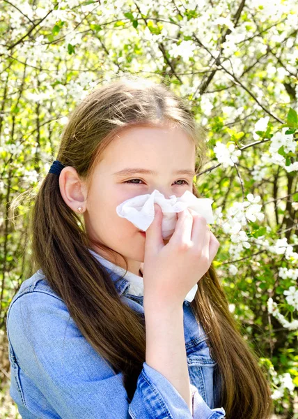 Niña tiene alergia a la primavera floreciendo y soplando sus nos —  Fotos de Stock