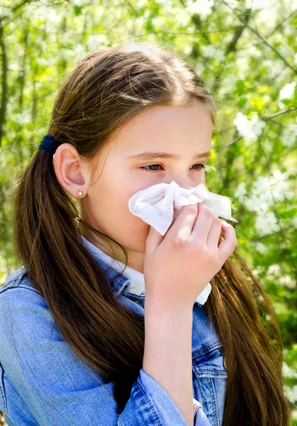 Niña tiene alergia a la primavera floreciendo y soplando sus nos — Foto de Stock