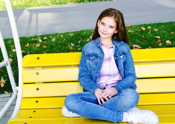 Portrét roztomilé usmívající se holčička sedí v pa — Stock fotografie