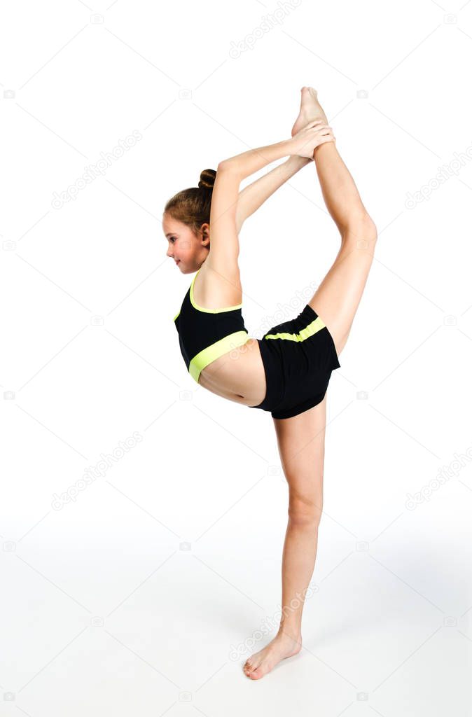 Flexible cute little girl child gymnast doing acrobatic exercise