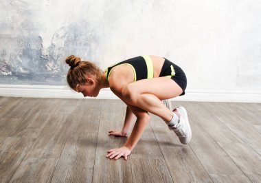 Esnek, küçük kız çocuk jimnastikçisi akrobatik egzersiz yapıyor.