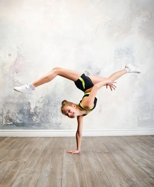 Ευέλικτο χαριτωμένο κοριτσάκι γυμναστής κάνει ακροβατική άσκηση — Φωτογραφία Αρχείου