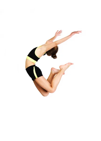 Гнучка мила маленька дівчинка гімнастка стрибає і отримує задоволення — стокове фото