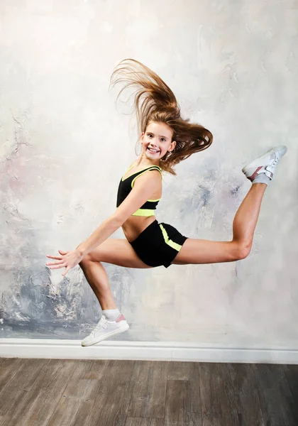 Гибкая милая маленькая девочка гимнастка прыгает и веселится . — стоковое фото