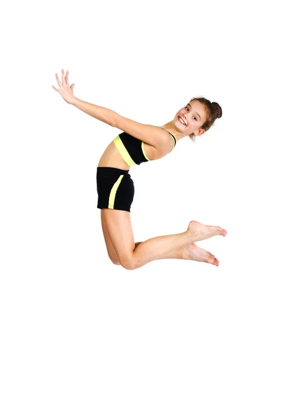 Гнучка мила маленька дівчинка гімнастка стрибає і отримує задоволення — стокове фото