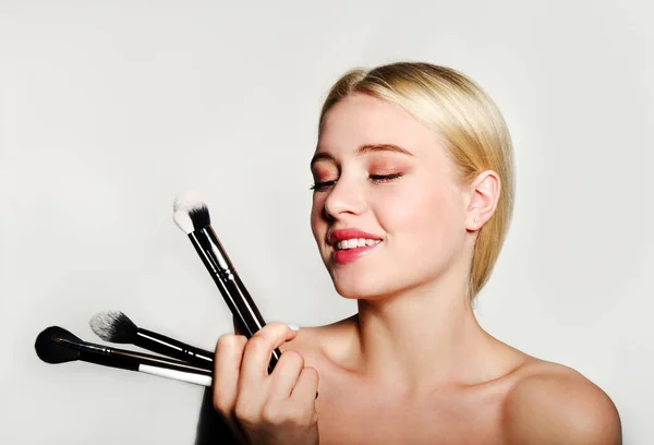 Portrait of beautiful blonde young woman face holding make up br — Stock Photo, Image