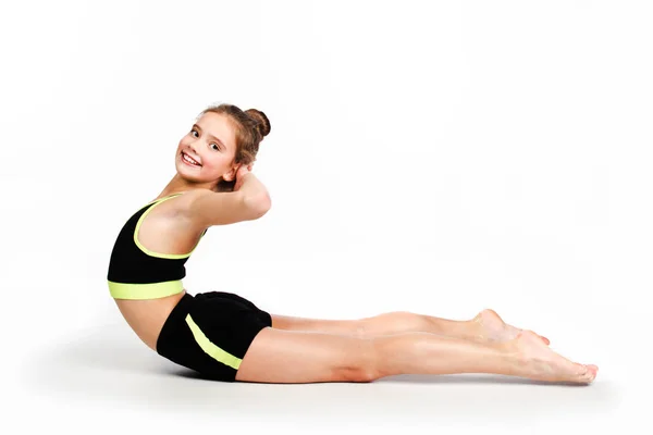 Esnek, küçük kız çocuk jimnastikçisi akrobatik egzersiz yapıyor. — Stok fotoğraf