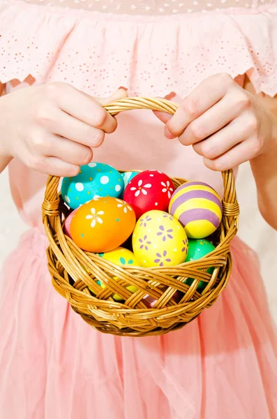 Niña sosteniendo una cesta con huevos de Pascua pintados a mano — Foto de Stock