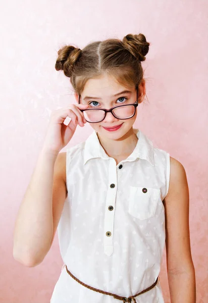 面白いです笑顔の女の子子供の肖像ピンクの背景に隔離された眼鏡をかけて — ストック写真