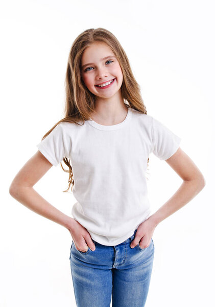 Portrait of adorable smiling little girl child preteen in jeans and white t-shirt isolated on a pink background