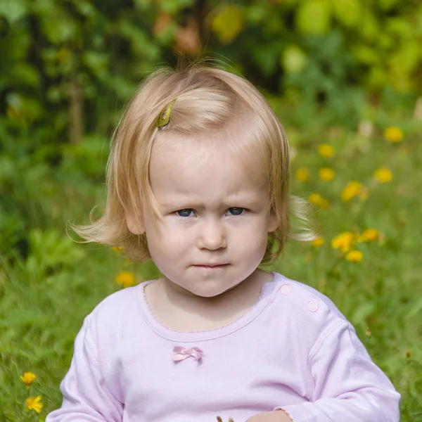 Klein meisje op een groen grasveld — Stockfoto