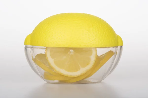 Прозрачный контейнер для лимона и нарезанный лимон внутри — стоковое фото