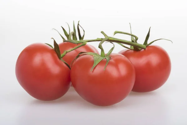 Los tomates rojos sobre la mesa sobre el fondo blanco — Foto de Stock