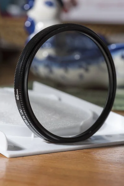 Polarizando el filtro CPL para la lente sobre la mesa en una caja abierta — Foto de Stock