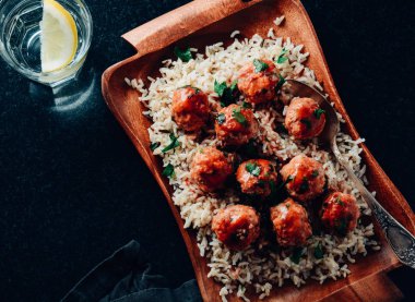 Ahşap plaka üzerinde pirinç ve domates soslu geleneksel Kızarmış köfte.