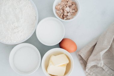 Hamur hazırlama. Malzemeler - un, yumurta ve pişirme aletleri ile dışarı rulo hamur. Beyaz ahşap zemin üzerinde. Üstten Görünüm