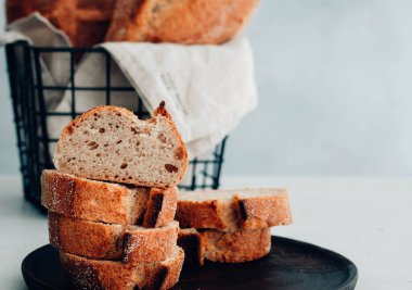 Ev yapımı beyaz buğday ekmek ahşap bir tabağa dilimlenmiş.