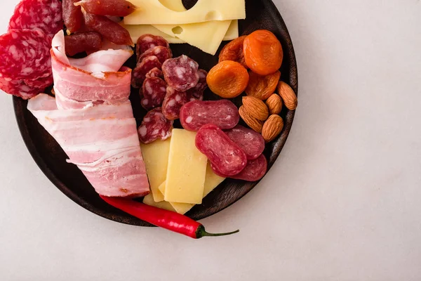 Cold snacks. Chopped sausage, bacon, olives,cheese. Top view. White background. Copy space.