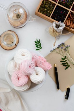 Ev yapımı zephyr veya marshmallow ile beyaz tabloda çay beyaz tabak içinde. Hatmi, beze, Zephyr. Sevgililer ya da anneler günü kavramı.