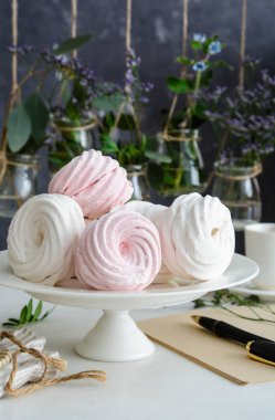 Ev yapımı zephyr veya marshmallow ile beyaz tabloda çay beyaz tabak içinde. Hatmi, beze, Zephyr. Sevgililer ya da anneler günü kavramı.