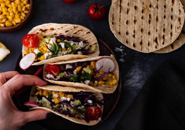 Çekti domuz tacos kırmızı lahana, domates, Mısır, beyaz peynir ve avokado ek yük vurdu.