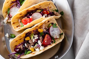 Mısır ekmeği ile ızgara tavuk fileto, guacamole sosu beyaz masada.