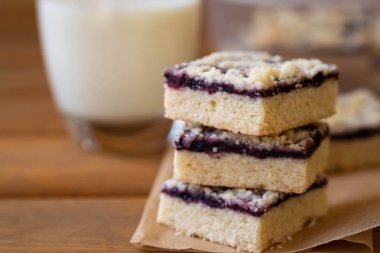 Kek veya reçelli kurabiye ya da marmelat tatlı kırıntıları, tarçın ve parşömen kağıt üzerine fındık ile yığını.