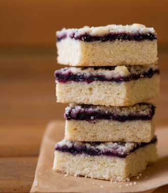 Kek veya reçelli kurabiye ya da marmelat tatlı kırıntıları, tarçın ve parşömen kağıt üzerine fındık ile yığını.