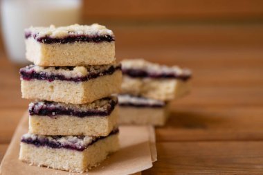 Kek veya reçelli kurabiye ya da marmelat tatlı kırıntıları, tarçın ve parşömen kağıt üzerine fındık ile yığını.