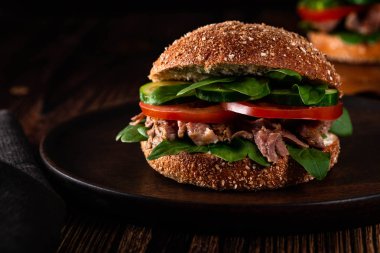 Izgara et, peynir, domates, salatalık, ıspanak koyu ahşap yüzeyi ile Burger. Reklam için idealdir. Yakın çekim