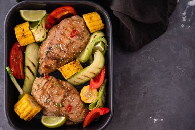 Siyah bir zemin üzerine Sebzeli tavuk ızgara fileto.