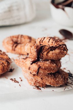 Beyaz bir arka plan üzerinde şeker ve çikolata soslu Churros.