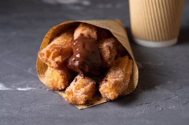 Sıcak çikolata ve kahve kağıt torba ile taze kızarmış churro (geleneksel İspanyol tatlı). Sokak gıda kavramı