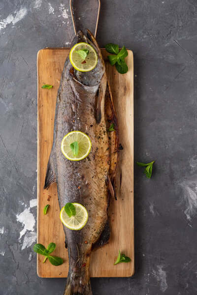 Baked pink salmon with lime on a wooden board.